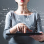 Geschäftsfrau mit einem Tablet-Computer, der das Symbol des Gleichgewichts einer Waage darstellt