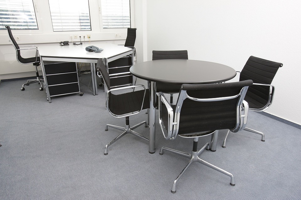 Voll ausgestattetes Büro mit Schreibtisch und Stühlen