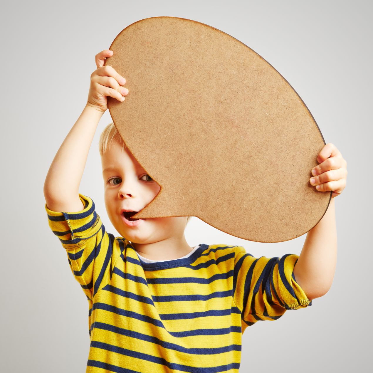Junge haelt grosse Sprechblase vor den Mund – Symbolbild fuer spielerische Sprachfoerderung bei Logopaedie Herdecke